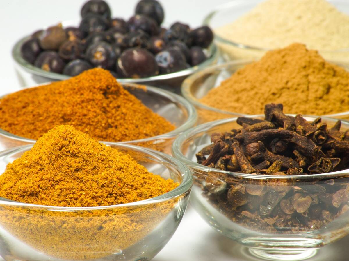 Bols de dal jaune et de curry entourés de petits tas d'épices en poudre